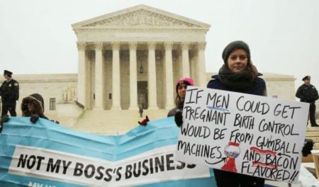 Protester Julia Mitchell holds a sign at the steps of the U.S. Supreme Court as arguments began to challenge the Affordable Care Act's requirement that employers pay for contraception and abortion-inducing drugs as part of an employee's healthcare, in Washington, March 25, 2014.