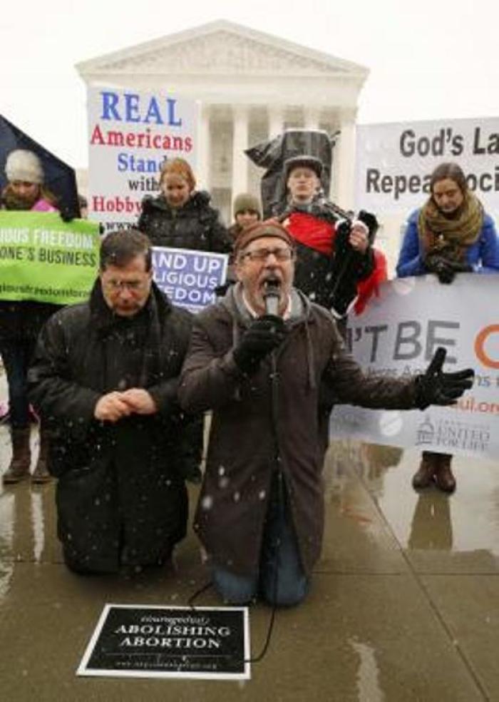 Father Frank Pavone (L) and the Rev. Patrick Mahoney pray at the steps of the U.S. Supreme Court as arguments begin to challenge the Affordable Care Act's requirement that employers provide coverage for Plan B and EllaOne morning after and week after pills and abortion-inducing drugs as part of an employee's healthcare, in Washington, March 25, 2014.