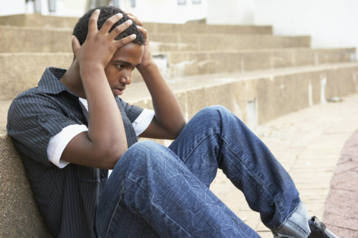 A young man holds his head in this undated file photo.