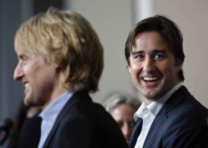 Co-director, writer and cast member Luke Wilson (R) smiles as his brother Owen (foreground) is interviewed at the premiere of 'The Wendell Baker Story' at the Writers Guild theater in Beverly Hills, California May 10, 2007. The movie marks Luke Wilson's directorial debut and opens limitedly in the U.S. on May 18.