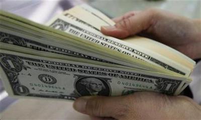 A woman counts U.S. dollars after exchanging her yen at a money changer at Haneda airport in Tokyo, Japan, Aug. 1, 2011.