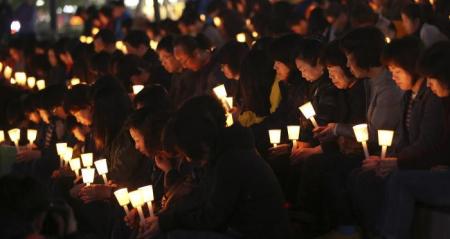 People take part in a candlelight vigil for missing passenger onboard the South Korean ferry Sewol, which capsized on last Wednesday, in Ansan April 21, 2014.