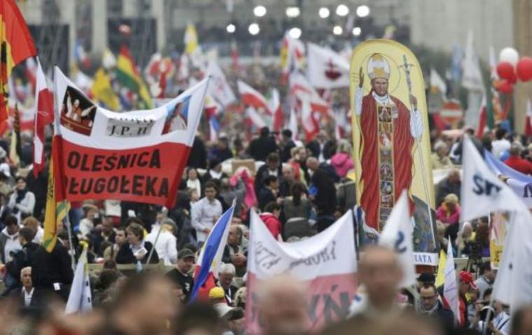 Polish pilgrims carrying flags and banners wait for a canonisation ceremony to start near St. Peter's Square at the Vatican April 27, 2014.