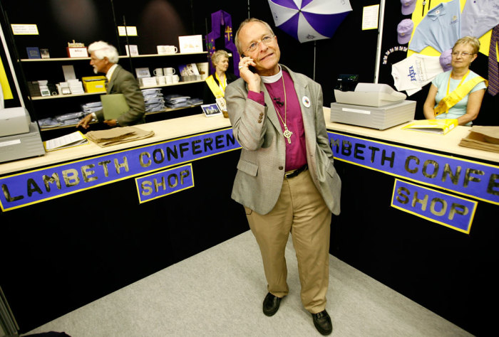 Bishop Gene Robinson from the U.S. the only openly gay bishop in the Anglican church speaks on his phone as he tours the 'market place' a collection of stalls run by Christian organizations on the fringes of the Lambeth Conference in Cantebury, southern England July 21, 2008. Robinson has been barred from attending the Lambeth conference, a meeting of bishops of the Anglican faith held once every 10 years, but is taking part in activities on the sidelines of the meeting.