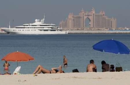 Tourists relax at Jumeirah beach, across from Nakheel's Palm Jumeirah and its flagship Atlatis hotel, in Dubai, November 28, 2009. World leaders expressed confidence in the global economic recovery Friday despite fears about a debt default by Gulf emirate Dubai, while major banks played down their exposure to the debt.