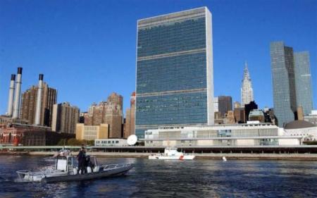 Coast Guard officers check a boat on the East River next to the United Nations complex before a General Assembly meeting in New York, Sept. 12, 2002.