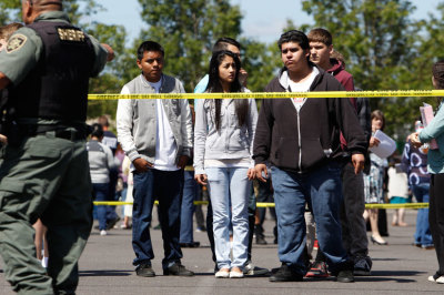 Students wait to be reunited with parents after a shooting at Reynolds High School in Troutdale, Oregon June 10, 2014. A gunman walked into the school and fatally shot a student on Tuesday before authorities found him dead a short time later, a day before students were due to finish classes and break for summer vacation.