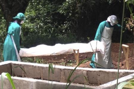 Health workers carry the body of an Ebola virus victim in Kenema, Sierra Leone, June 25, 2014.