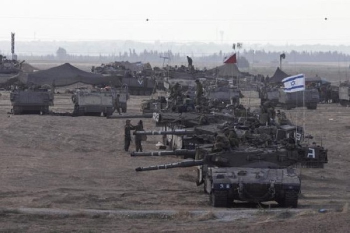 Israeli tanks and armoured personnel carriers (APCs) are seen at a staging area outside the central Gaza Strip July 15, 2014.