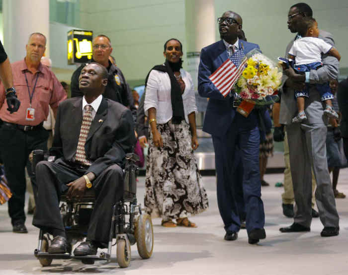 Mariam Yahya Ibrahim (C) arrives at the airport in Manchester, New Hampshire with family members, including her husband Daniel Wani (L) and his brother Gabriel Wani (R), July 31, 2014.