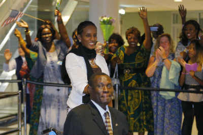 Mariam Yahya Ibraheem (C) and her husband Daniel Wani (bottom) are greeted by a cheering crowd of people as they arrive at the airport in Manchester, New Hampshire, July 31, 2014.