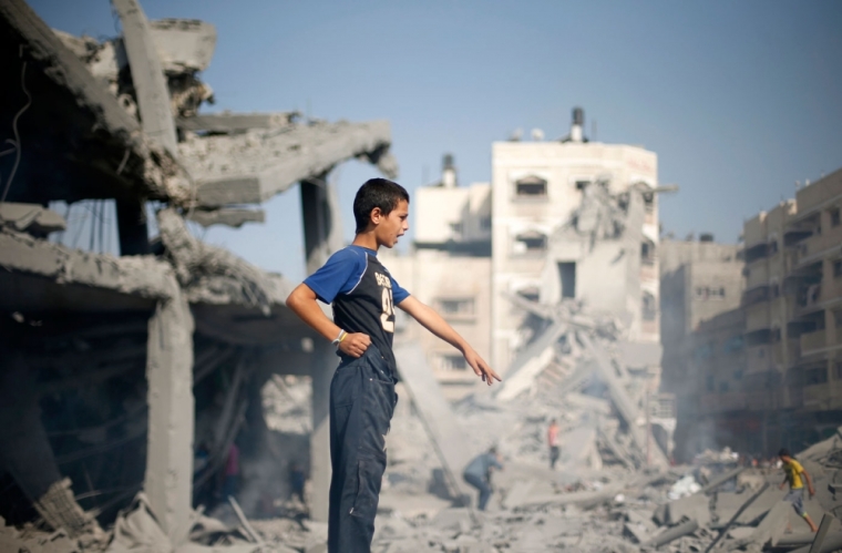 A Palestinian boy gestures as he stands atop the debris of a mosque, which witnesses said was hit in an Israeli air strike, in Gaza City August 2, 2014. Hamas claimed responsibility on Saturday for a deadly Gaza Strip ambush in which an Israeli army officer may have been captured, but said the incident likely preceded and therefore had not violated a U.S.- and U.N.-sponsored truce. Palestinian officials say 1,650 Gazans, most of them civilians, have been killed, including a muezzin who died in an Israeli strike on a northern mosque on Saturday. Sixty-three Israeli soldiers have been killed, and Palestinian shelling has killed three civilians in Israel. Israel launched a Gaza air and naval offensive on July 8 following a surge of cross-border rocket salvoes by Hamas and other Palestinian guerrillas, later escalating into ground incursions centred along the tunnel-riddled eastern frontier of the enclave but often pushing into residential areas.