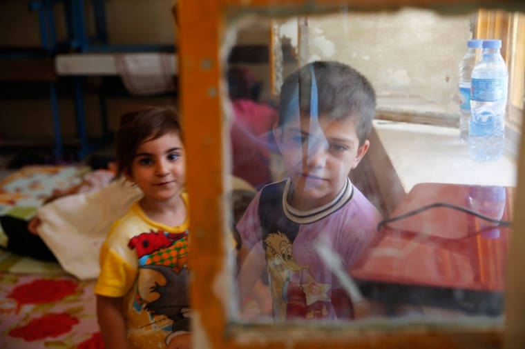 Children of a Christian family, who fled from the violence in Mosul two days ago, stay at a school in Arbil, in Iraq's Kurdistan region June 27, 2014. Iraqi forces launched an airborne assault on rebel-held Tikrit on Thursday with commandos flown into a stadium in helicopters, at least one of which crashed after taking fire from insurgents who have seized northern cities.