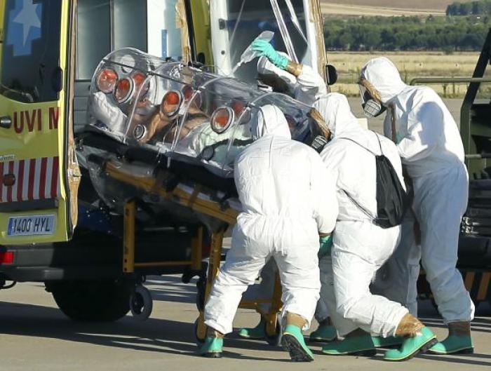 Health workers load Ebola patient, Spanish priest Miguel Pajares, into an ambulance on the tarmac of Torrejon airbase in Madrid, after he was repatriated from Liberia for treatment in Spain, August 7, 2014.