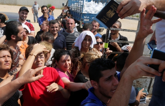 Iraqi families displaced by the violence in their country receive aid from a Chaldean Catholic Church truck in Beirut, Lebanon, August 13, 2014. Well financed and armed, Islamic State insurgents have captured large swathes of territory in a summer offensive, as the Iraqi army. Kurdish Peshmerga forces in the self-governing north have crumbled in the face of its onslaught, massacring Shi'ites and minority Christians and Yazidis as they advance.