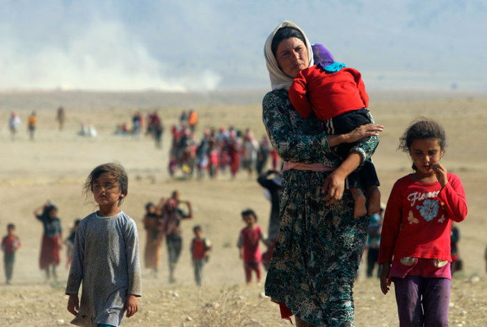 Displaced people from the minority Yazidi sect, fleeing violence from forces loyal to the Islamic State in Sinjar town, walk towards the Syrian border, on the outskirts of Sinjar mountain, near the Syrian border town of Elierbeh of Al-Hasakah Governorate August 11, 2014. Islamic State militants have killed at least 500 members of Iraq's Yazidi ethnic minority during their offensive in the north, Iraq's human rights minister told Reuters on Sunday. The Islamic State, which has declared a caliphate in parts of Iraq and Syria, has prompted tens of thousands of Yazidis and Christians to flee for their lives during their push to within a 30-minute drive of the Kurdish regional capital Arbil.