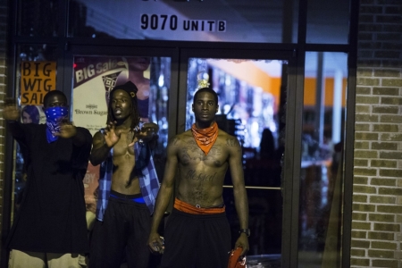 Demonstrators blocked the entrance of a store that had been broken into early Saturday morning in an attempt to stop potential looters from entering.