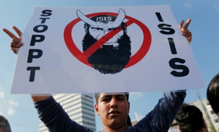 A Kurd of the ethnic minority of Yazidis holds up a placard reading 'Stop IS' during a demonstration in Bielefeld, Aug. 9, 2014. Some 10,000 ethnic Kurds of the Yazidis sect, who practice an ancient faith related to Zoroastrianism, protested in the western German city on Saturday against Islamic State militants, who are surging across northern Iraq near the Kurdistan borders in their drive to eradicate unbelievers such as Christians and Yazidis.