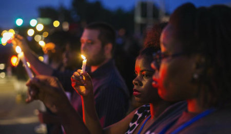 Protesters hold candles during a peaceful demonstration, as communities react to the shooting of Michael Brown in Ferguson, Missouri.