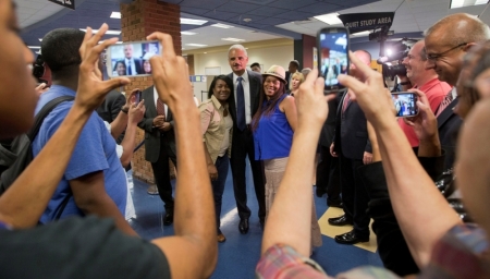 Attorney General Eric Holder (C) poses for photographs following his meeting with students at St. Louis Community College Florissant Valley in Ferguson, Missouri, Aug. 20, 2014. Holder visited Ferguson, Missouri, on Wednesday, hours after nearly 50 protesters were arrested in the 11th straight night of demonstrations over the Aug. 9 fatal shooting of Michael Brown, an unarmed black teenager, by a white police officer. The St. Louis County prosecutor's office will also begin presenting evidence on Wednesday to a regularly seated grand jury investigating the shooting death of Brown.