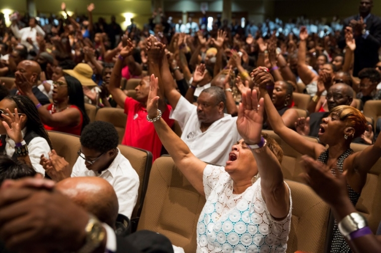 Hundreds raise their hands during funeral services for Michael Brown at Friendly Temple Missionary Baptist Church in St. Louis, Aug. 25, 2014. Family, politicians and activists gathered for the funeral on Monday following weeks of unrest with at times violent protests spawning headlines around the world focusing attention on racial issues in the United States.