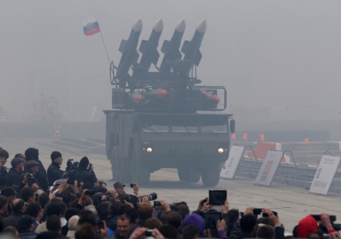 Spectators watch a Russian 'Buk' missile system being driven during the 'Russia Arms Expo 2013' Ninth international exhibition of arms, military equipment and ammunition, in the Urals city of Nizhny Tagil, Sept. 25, 2013.