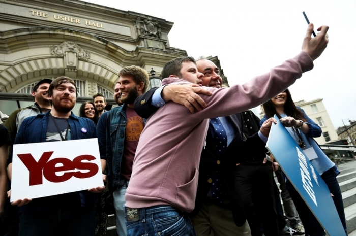 Scotland's First Minister Alex Salmond poses for a selfie with a fan, as he stands with local pop stars during an event in Edinburgh, Scotland, Sept. 14, 2014. The referendum on Scottish independence will take place on Sept. 18, when Scotland will vote whether or not to end the 307-year-old union with the rest of the United Kingdom.