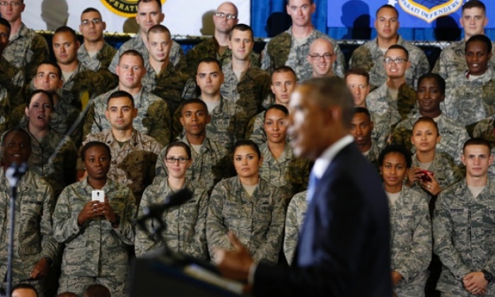 Military personnel listen as President Barack Obama speaks.