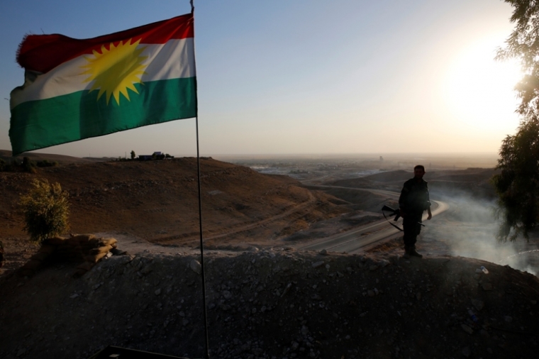 A Kurdish Peshmerga fighter looks down the road to Makhmur that was retaken from the Islamic Sate, south of Erbil, Iraq, September 10, 2014.