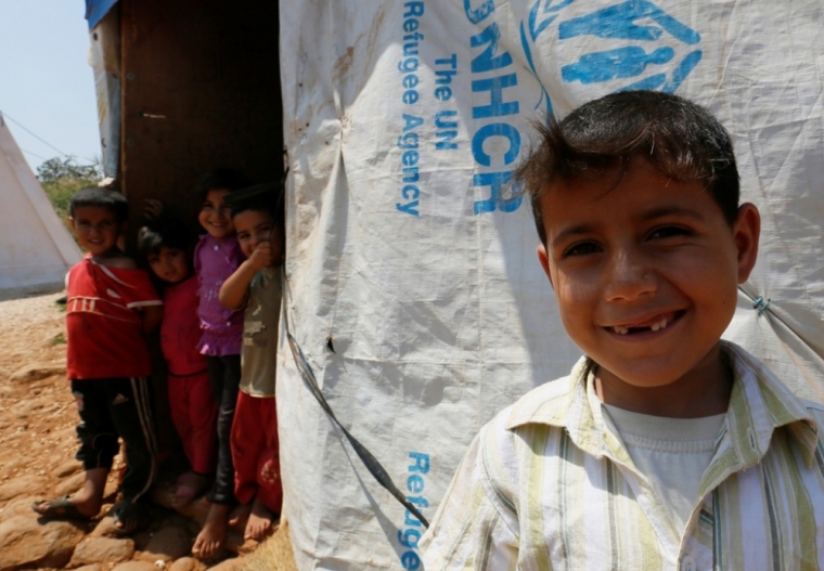 Syrian children stand in front of their tent after they and their families fled from Raqqa in Syria to Lebanon, in Wazzani village near the Israeli border in south Lebanon August 30, 2014. Three million Syrian refugees will have registered in neighboring countries, but many remain trapped by the advance of Islamist militants or are having difficulty in reaching open border crossings, the United Nations said.