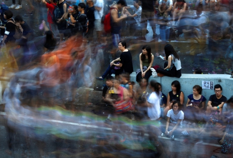 Protesters block the main street to the financial Central district outside of the government headquarters building in Hong Kong, October 1, 2014. Thousands of pro-democracy protesters thronged the streets of Hong Kong on Wednesday, ratcheting up pressure on the pro-Beijing government that has called the action illegal, with both sides marking uneasy National Day celebrations.