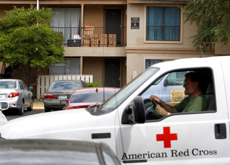 A Red Cross worker leaves after delivering food to the apartment unit in The Ivy Apartments where a man diagnosed with the Ebola virus was staying in Dallas, Texas, October 2, 2014. Up to 100 people may have had direct or indirect contact with the first person diagnosed with Ebola in the United States, and four people have been quarantined in a Dallas apartment, health officials said on Thursday.