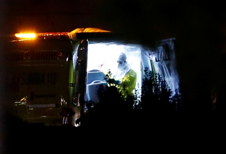 A medical worker in protective gear stands next to a special stretcher carrying a Spanish nurse who was infected by Ebola, outside Alcorcon's hospital, near Madrid, Spain, early October 7, 2014. A Spanish nurse has become the first person to contract Ebola outside of Africa, casting doubt over measures taken in Spain to control the potential spread of the deadly disease.