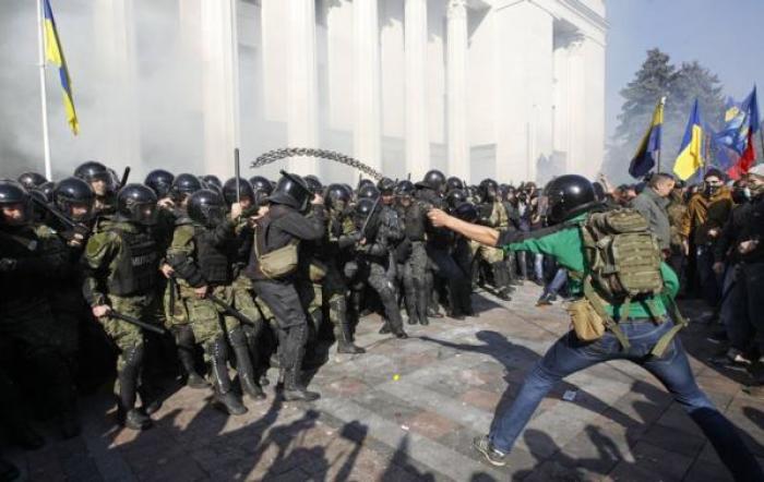 Radical protesters (R) clash with Interior Ministry and law enforcement members on the Day of Ukrainian Cossacks, marked by activists and supporters of the All-Ukrainian Union Svoboda (Freedom) Party and far-right activists and nationalists to honour the role of the movement in the history of Ukraine, during a rally near the parliament building in Kiev, October 14, 2014.