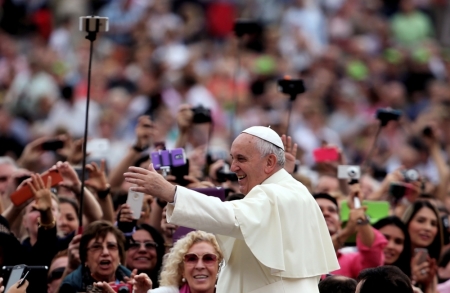 Pope Francis waves as he leads his weekly audience in Saint Peter's Square at the Vatican, October 15, 2014.