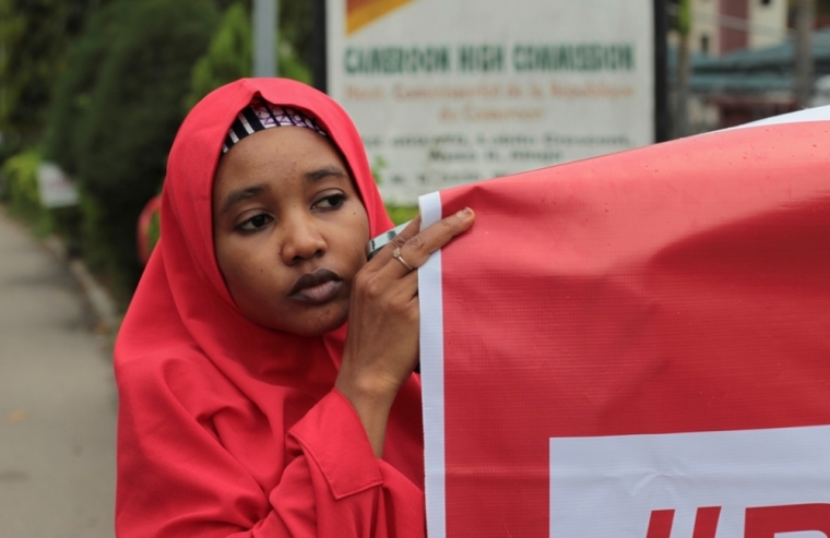 A campaigner from '#Bring Back Our Girls' hold a banner during a rally calling for the release of the Chibok school girls who were abducted by the Boko Haram militants, outside the Cameroon Embassy in Abuja, Nigeria, October 17, 2014. Nigeria said on Friday it had agreed a ceasefire with Islamist militants Boko Haram and reached a deal for the release of more than 200 schoolgirls kidnapped by the group six months ago.