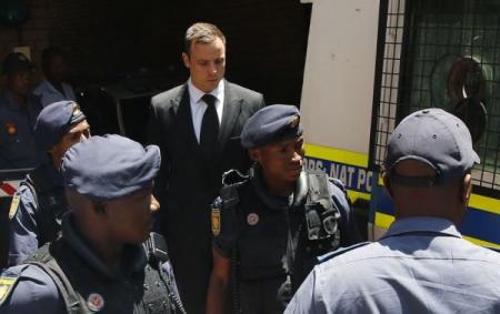 South African Olympic and Paralympic sprinter Oscar Pistorius (C ) is escorted to a police van after his sentencing at the North Gauteng High Court in Pretoria October 21, 2014.