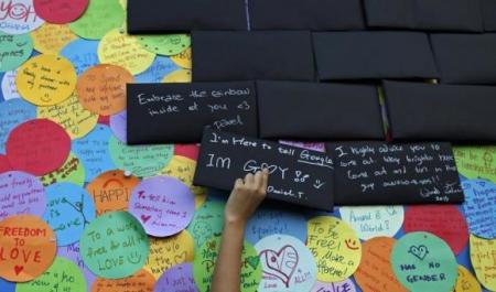 A participant puts up a sign about his sexuality before taking part in the forming of a giant pink dot at the Speakers' Corner in Hong Lim Park in Singapore June 29, 2013.