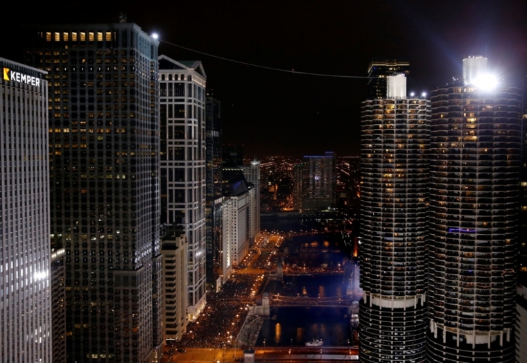 Daredevil Nik Wallenda walks along a tightrope between two skyscrapers suspended 500 feet (152.4 meters) above the Chicago River in Chicago, Illinois, November 2, 2014.