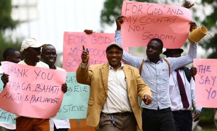 Ugandan anti-homosexuality activist pastor Martin Ssempa (C) leads supporters as they celebrate after Uganda's President Yoweri Museveni signed a bill into law that strengthened existing punishments, such as imposing jail terms of up to life for 'aggravated homosexuality' - including sex with a minor or while HIV positive, Kampala, February 24, 2014. Gay activists in Uganda said they planned a legal challenge.