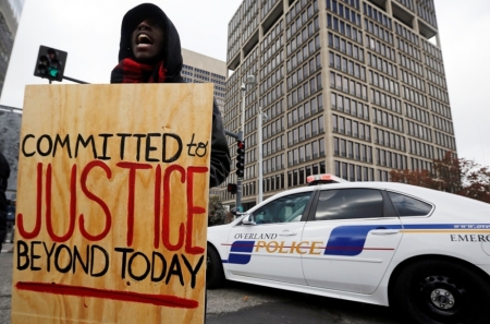 A demonstrator yells as he blocks a street intersection during a protest over the shooting death of Michael Brown in Clayton, Missouri, November 17, 2014.