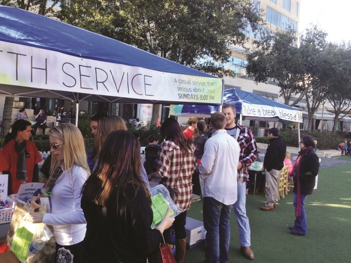 Members of Memorial Drive Presbyterian Church serving at a local shopping mall inviting and helping patrons put together a 'Bless Bag' to take the bag with them to give to one of Houston's homeless.