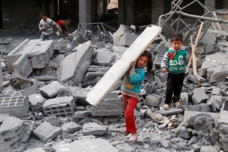 Children collect items from among the debris of a school for the deaf and mute, destroyed in what activists said were overnight U.S.-led air strikes against the Islamic State, in Raqqa November 24, 2014. Raqqa, in eastern Syria, is controlled by the Islamic State. The United States and its allies have conducted two dozen strikes against Islamic State militants since Friday, launching nine strikes in Syria and 15 strikes in Iraq, according to U.S. Central Command.