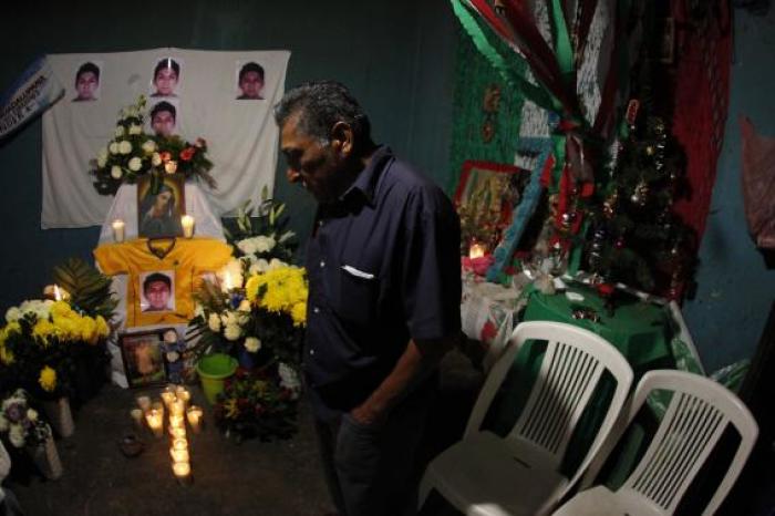 Ezequiel Mora, father of Alexander Mora Venancio stands in front of an altar with pictures of his son at his house in El Pericon, in the southern Mexican state of Guerrero, December 7, 2014.