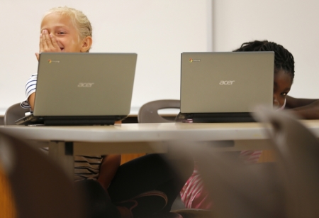 Grade four students react to a camera in their classroom at Monarch School in San Diego, California October 8, 2013. While most of San Diego County is wired for broadband access, the Public Policy Institute of California reports 23 percent of local residents have not connected to a service. Students are going home with digital assignments, or with school-issued technology, but with no active broadband connection in the home, according to a media release.