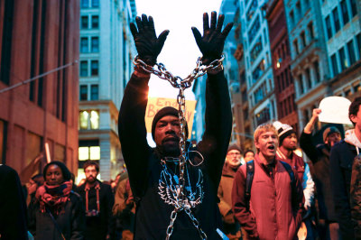 A man with a chain on his body takes part in a march against police violence, in New York December 13, 2014. Thousands marched in Washington, New York and Boston on Saturday to protest killings of unarmed black men by police officers. Organizers said the marches were among the largest in the recent wave of protests against the killings of black males by officers in Ferguson, Missouri; New York; Cleveland; and elsewhere.