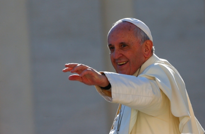 Pope Francis, who's 78th birthday is today, waves as he leaves at the end of his general audience in Saint Peter's Square at the Vatican, December 17, 2014.