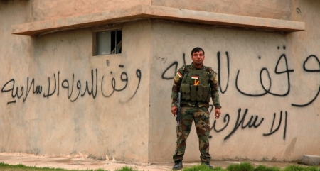 A Kurdish Peshmerga fighter stands guard in Zumar, Nineveh province December 18, 2014. Kurdish peshmerga fighters have fought their way to Iraq's Sinjar mountain and freed hundreds of people trapped there by Islamic State fighters, head of the Iraqi Kurdish region's national security council Masrour Barzani said on Thursday. The assault, backed by U.S. air strikes, ended the months-long ordeal of hundreds of people from Iraq's Yazidi religious minority, who had been besieged on the mountain since Islamic State stormed Sinjar and other Kurdish-controlled parts of northern Iraq in August.