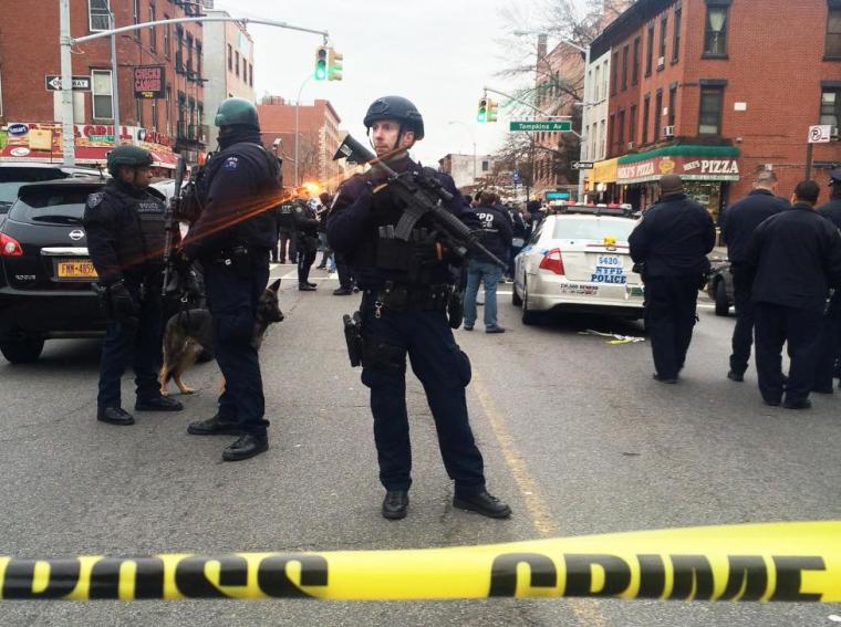 Police officers block off the scene of a a shooting incident where a gunman killed two New York police officers as they sat in their squad car before turning his weapon on himself in New York, December 20, 2014.