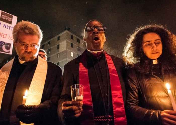 Mourners take part in a prayer vigil at the site where two New York Police Department (NYPD) officers were fatally shot in the Brooklyn borough of New York December 21, 2014. New York Mayor Bill de Blasio faced the biggest crisis of his time in office on Sunday following the fatal shooting of two police officers, in an attack intended as retribution for recent U.S. police killings of unarmed black men. Police said the daylight Saturday shooting was the work of a 28-year-old black man who traveled from Baltimore that day after shooting and wounding his girlfriend, having warned on social media that he planned to be 'putting wings on pigs,' using an anti-police slur.